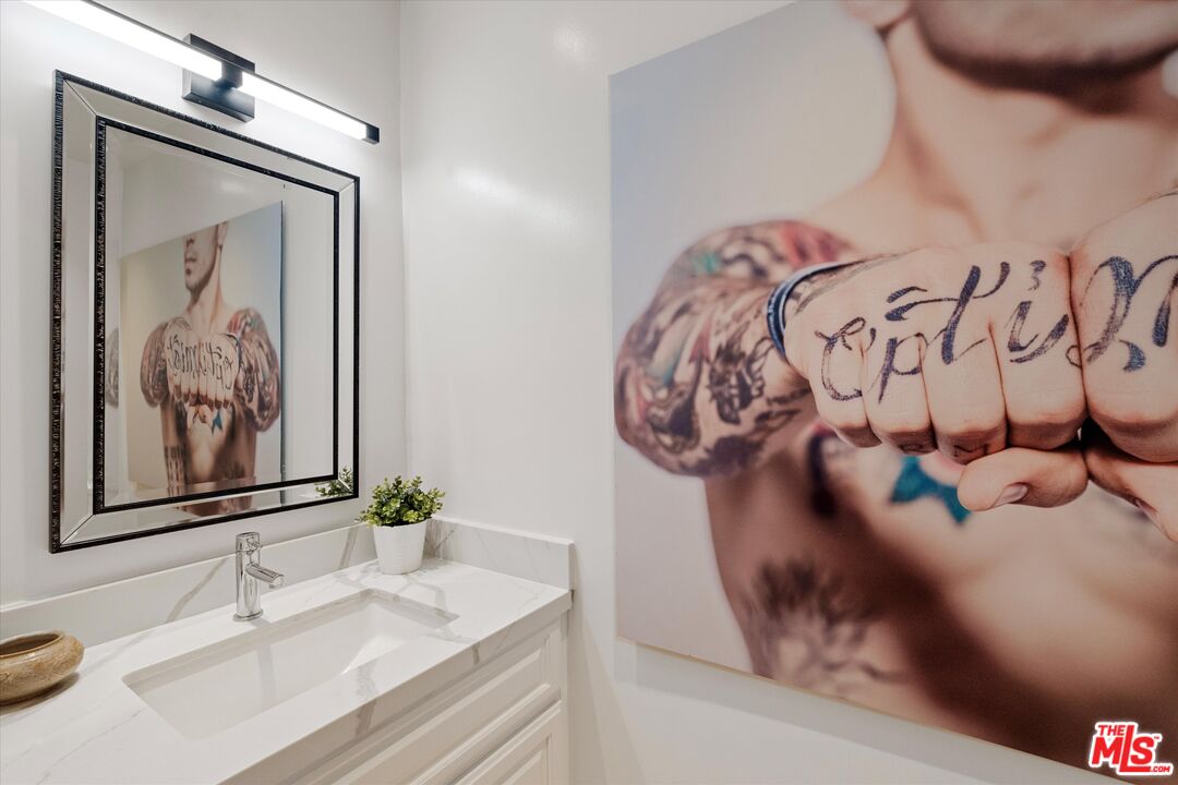 2108 Neilson Way Santa Monica, CA 90405 - Photo 13 of 70 a bathroom with a sink and mirror with painted walls