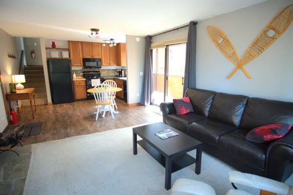 a dining room with furniture a chandelier and wooden floor