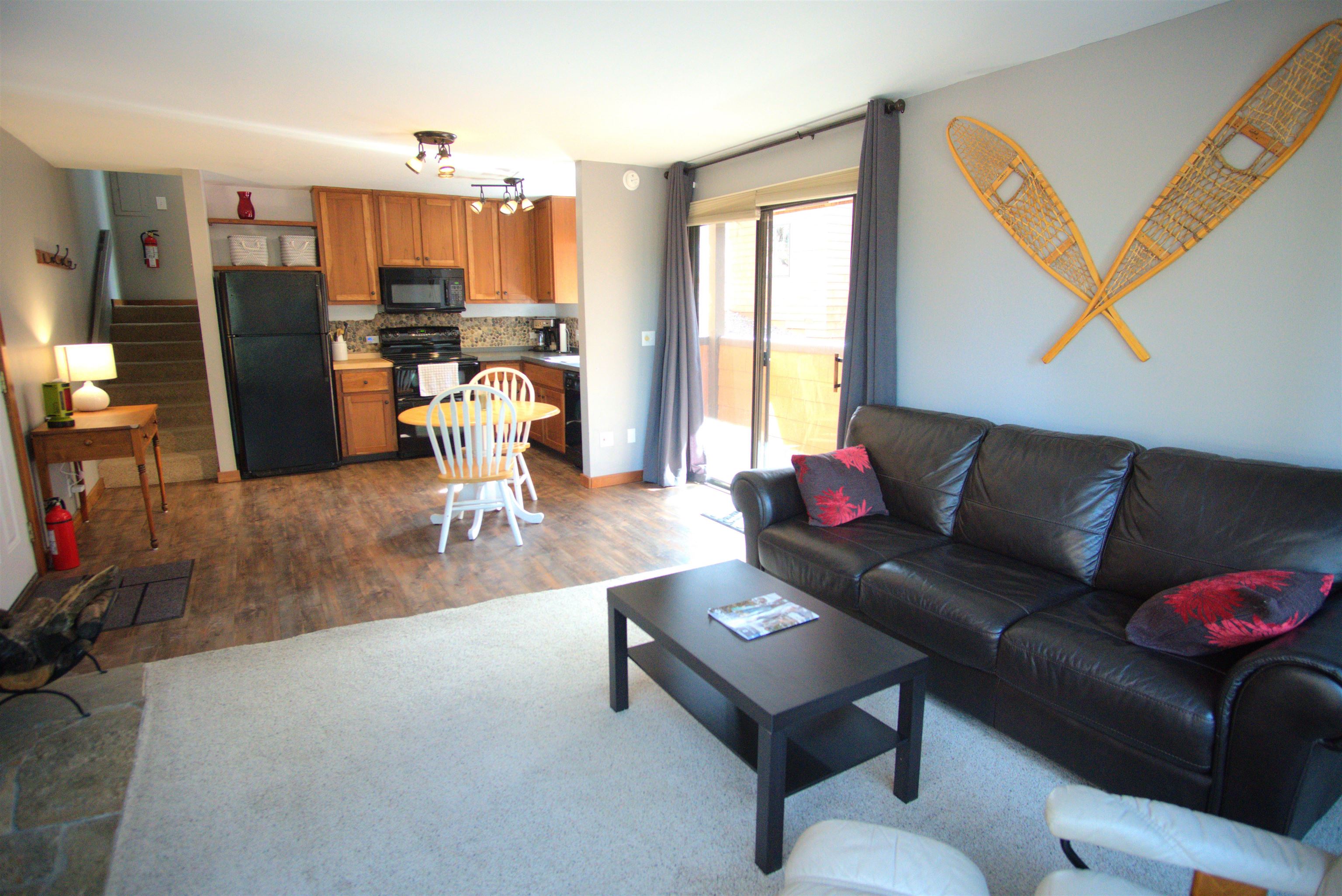 a living room with furniture and a kitchen