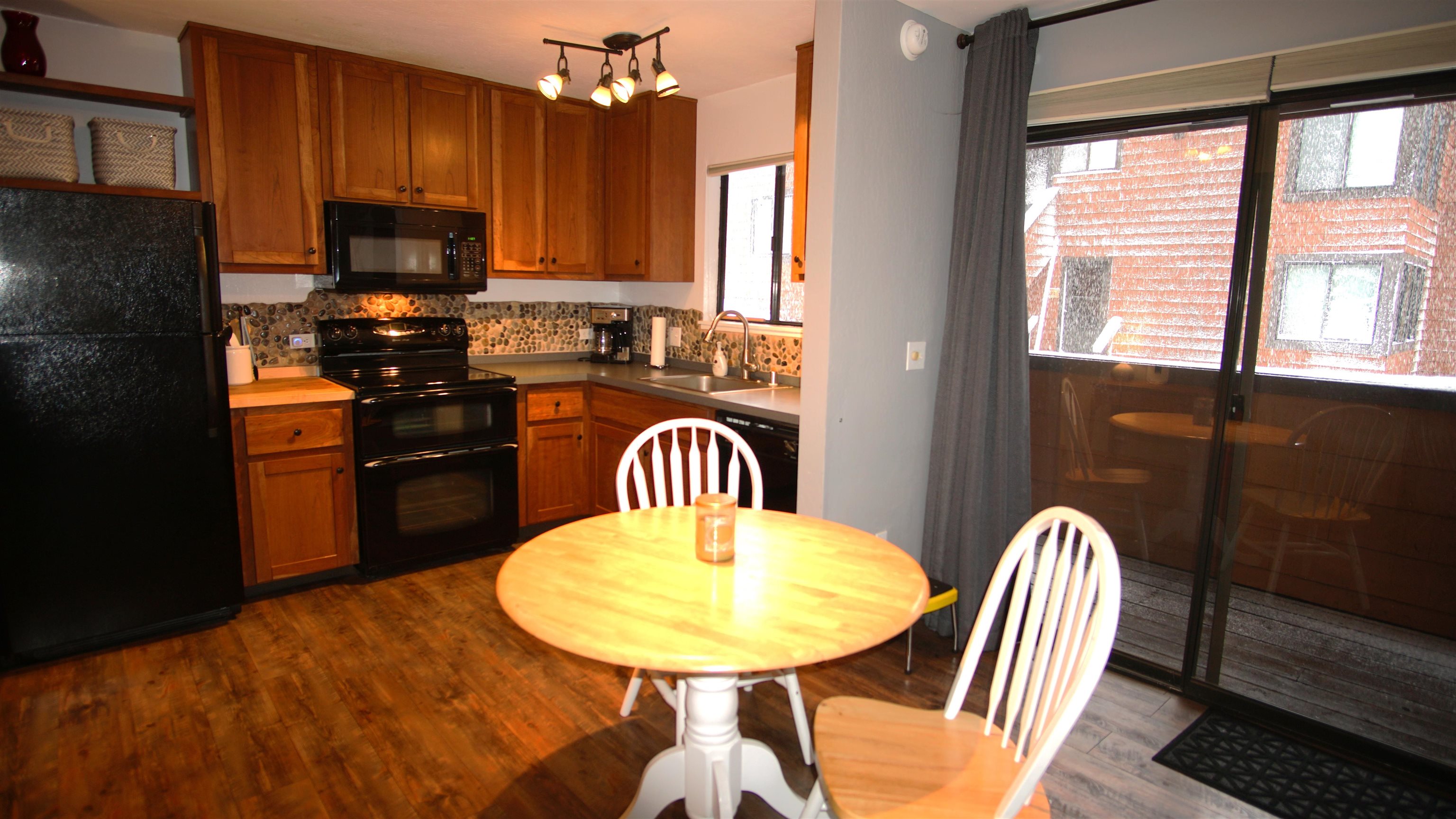 11723 Snowpeak Way, Unit 567 Truckee, CA 96161 - Photo 12 of 28 a kitchen with stainless steel appliances granite countertop a kitchen island a stove a table and a refrigerator