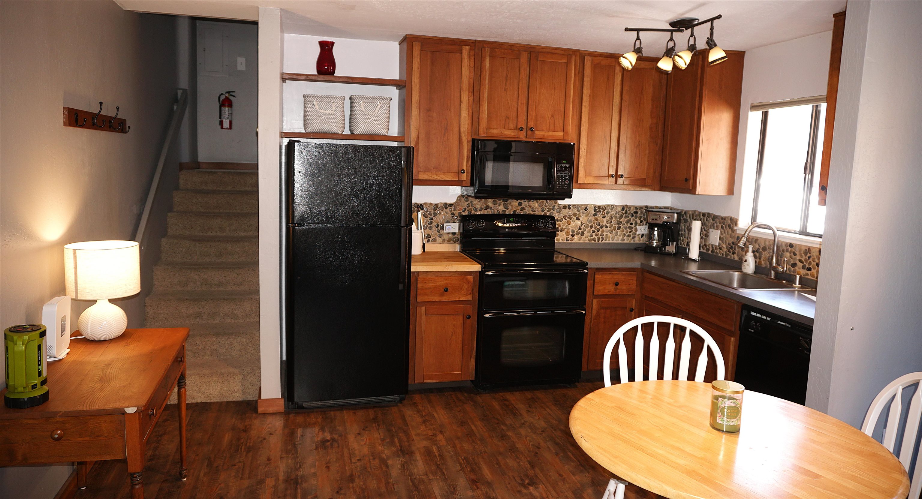 11723 Snowpeak Way, Unit 567 Truckee, CA 96161 - Photo 22 of 28 a kitchen with stainless steel appliances granite countertop a refrigerator a stove a sink dishwasher a dining table and chairs with wooden floor