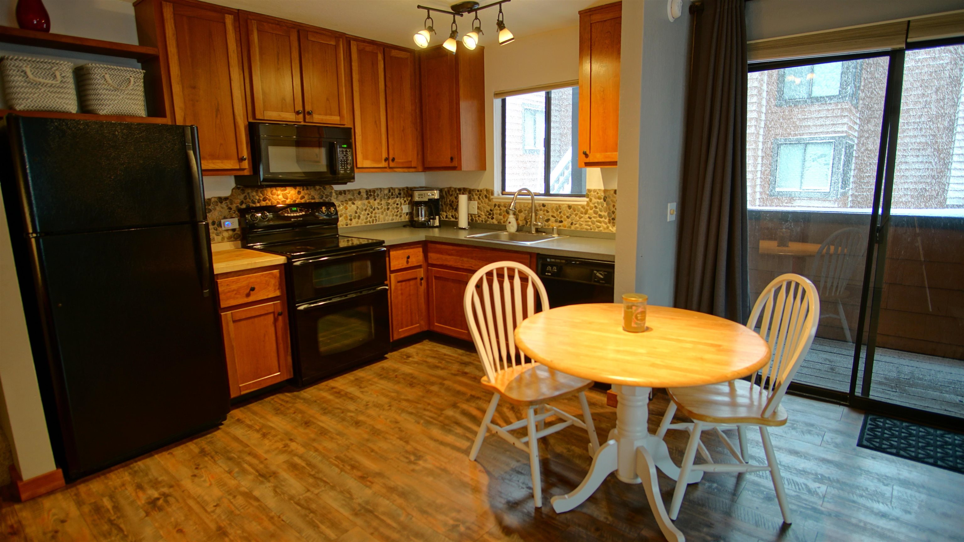 11723 Snowpeak Way, Unit 567 Truckee, CA 96161 - Photo 3 of 28 a kitchen with stainless steel appliances granite countertop a dining table chairs refrigerator and sink