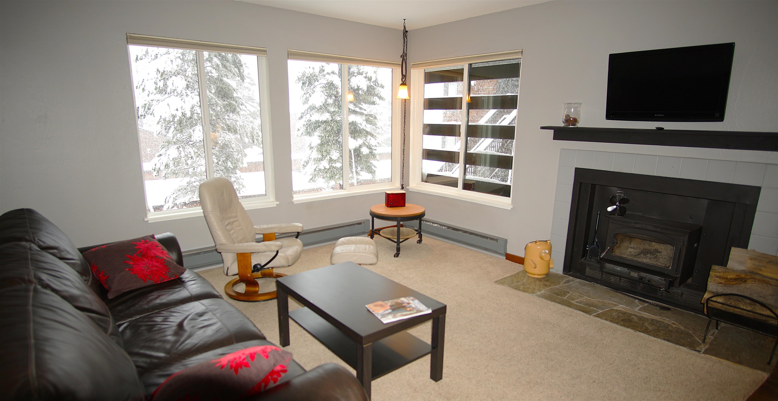 11723 Snowpeak Way, Unit 567 Truckee, CA 96161 - Photo 9 of 28 a living room with furniture a flat screen tv and a fireplace