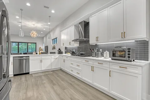 a kitchen with granite countertop white cabinets and white appliances