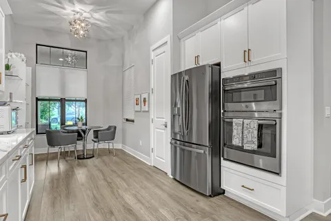 a kitchen with granite countertop stainless steel appliances a dining table and chairs
