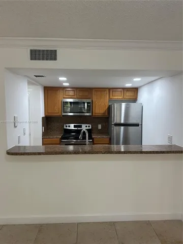 a kitchen with stainless steel appliances granite countertop a sink a stove and a refrigerator