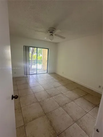 an empty room with windows and ceiling fan