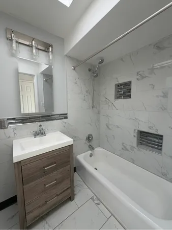 a bathroom with a tub sink and mirror