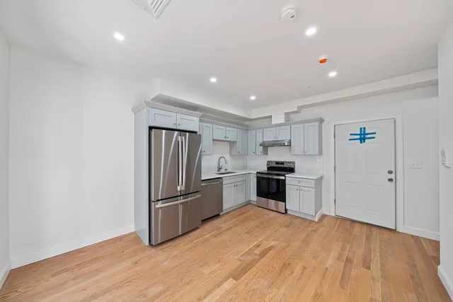 a kitchen with stainless steel appliances granite countertop a refrigerator and a stove top oven
