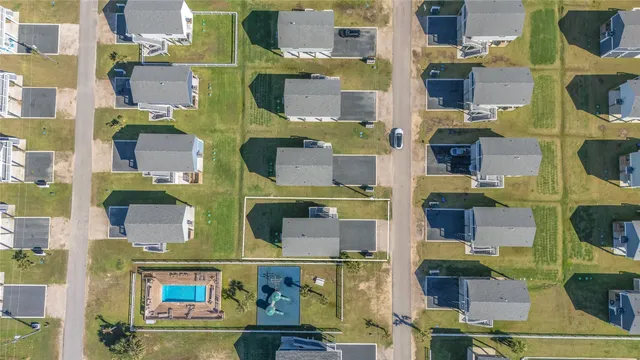 an aerial view of residential houses with outdoor space and swimming pool