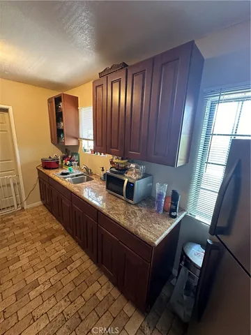 a kitchen with kitchen island granite countertop a sink stove and cabinets