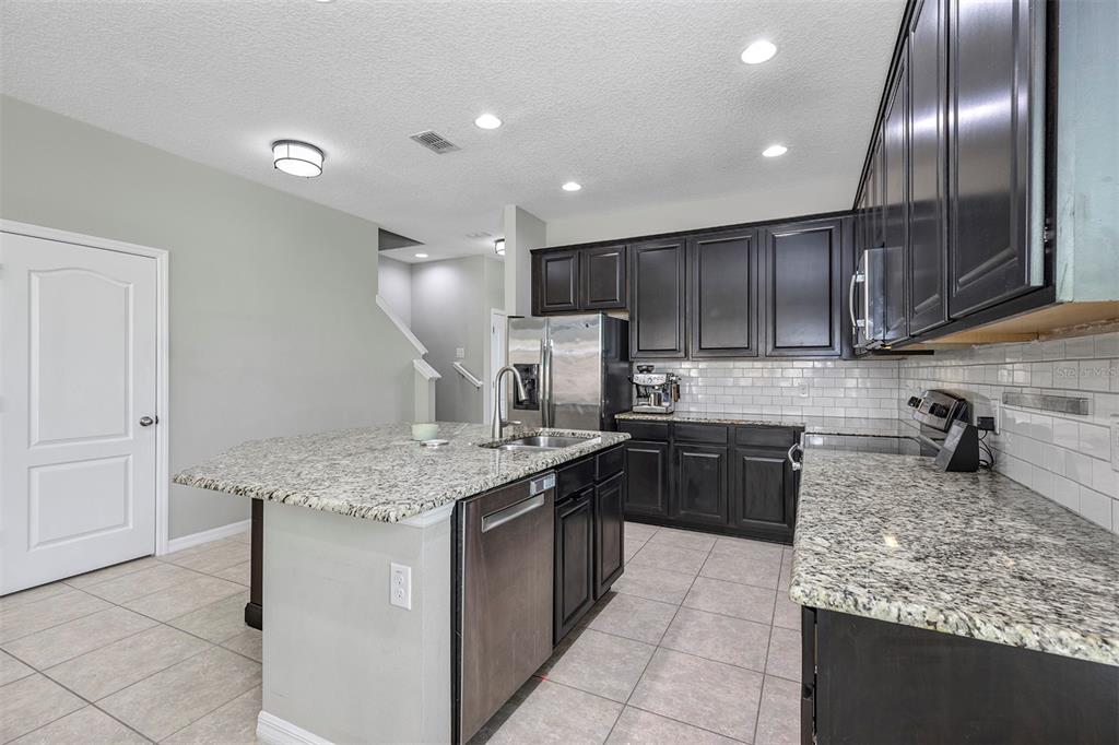 7644 Ripplepointe Way Windermere, FL 34786 - Photo 6 of 52 a kitchen with stainless steel appliances granite countertop granite counter tops refrigerator a stove top oven and cabinets