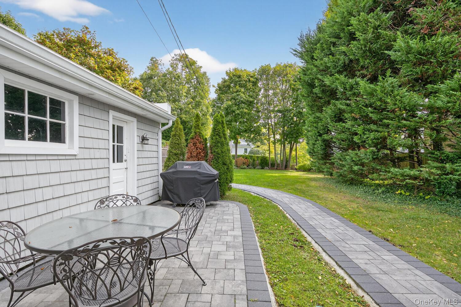 20 Locust Place Locust Valley, NY 11560 - Photo 16 of 16 a view of a chair and table in backyard of the house