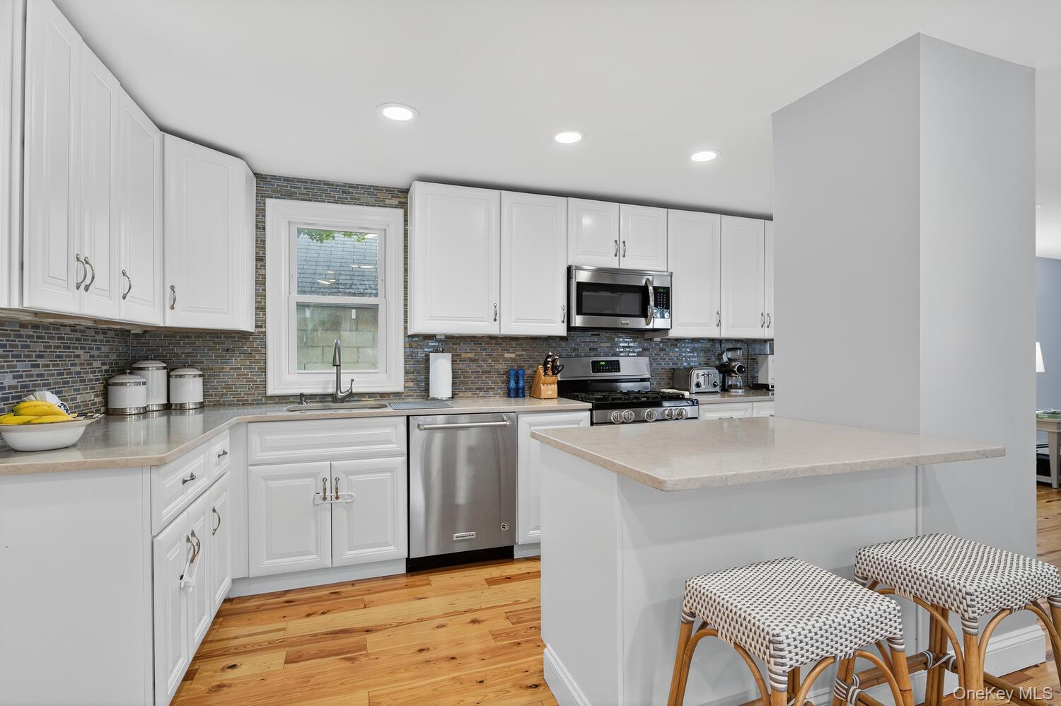 20 Locust Place Locust Valley, NY 11560 - Photo 7 of 16 a kitchen with a sink white cabinets and stainless steel appliances