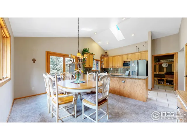 a dining hall view with a dining table chairs and large window