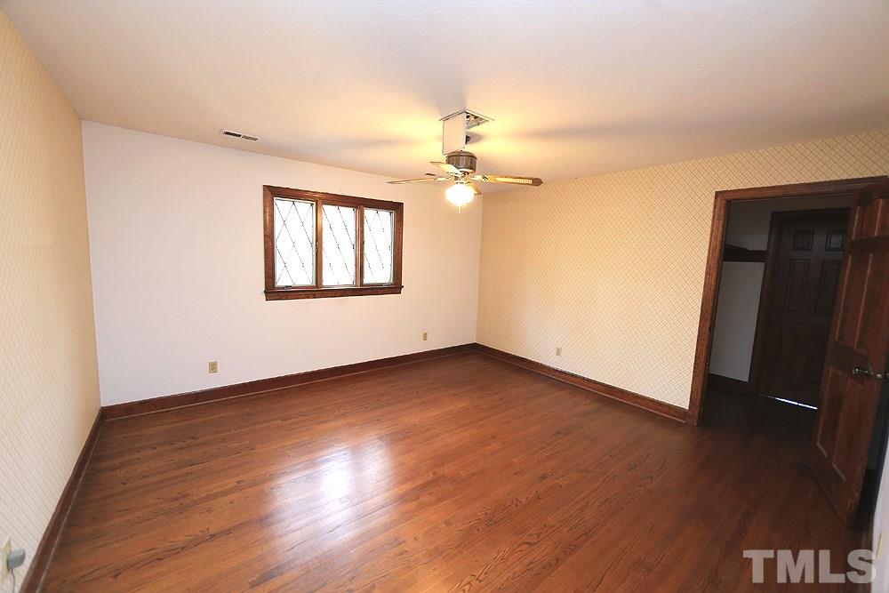 4316 Oak Park Road Raleigh, NC 27612 - Photo 20 of 30 an empty room with wooden floor chandelier fan and windows