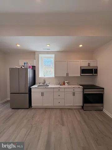 a kitchen with cabinets and wooden floor