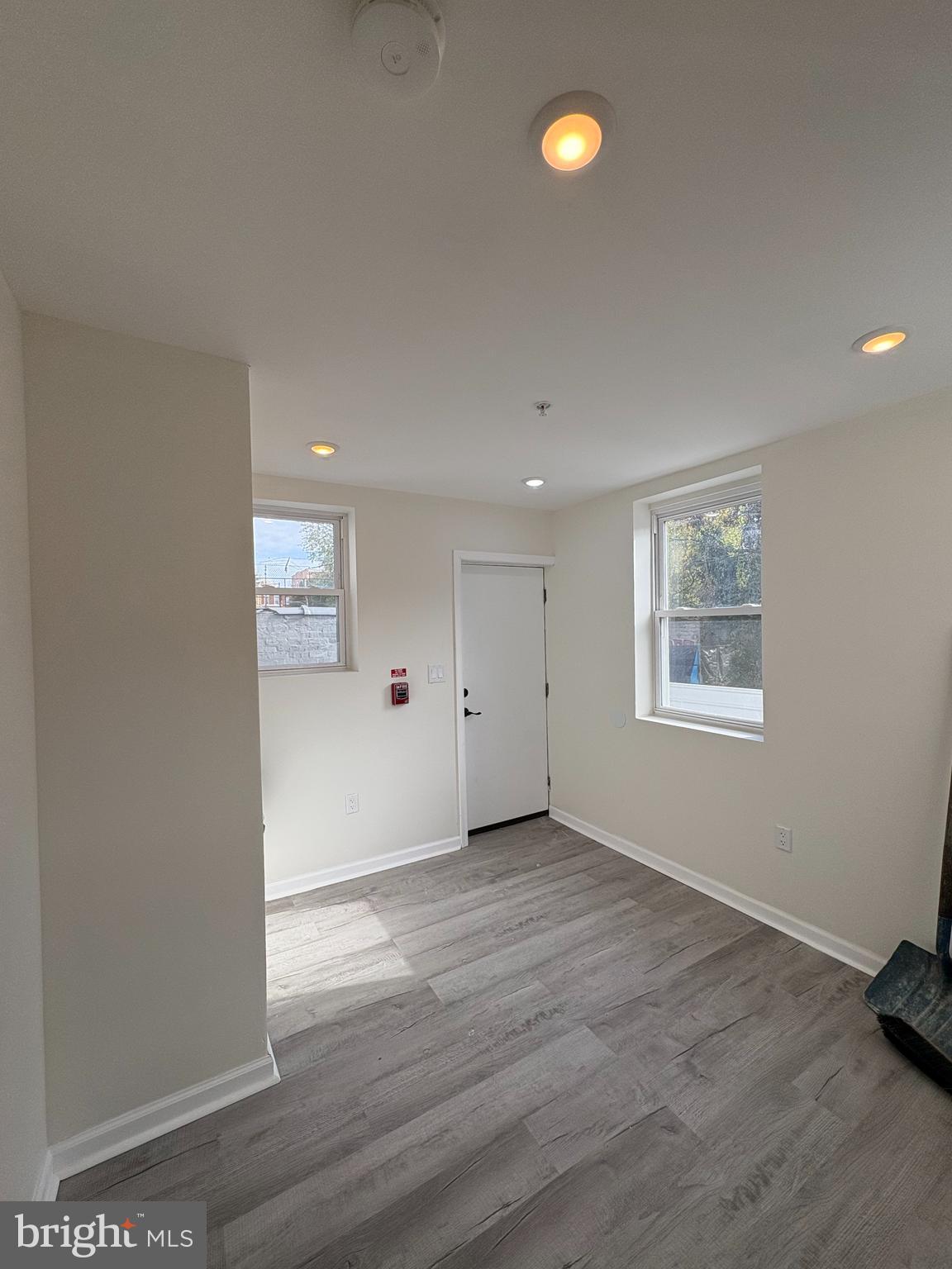 3625 North 22nd Street, Unit 1 Philadelphia, PA 19140 - Photo 9 of 10 an empty room with wooden floor and windows