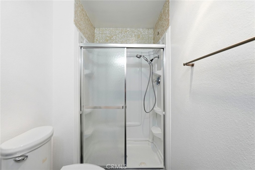 7890 East Spring Street, Unit 11E Long Beach, CA 90815 - Photo 23 of 40 a bathroom with a shower and toilet