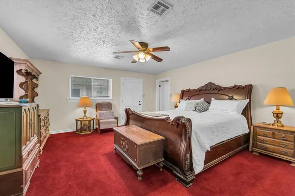 a spacious bedroom with a bed and a chandelier