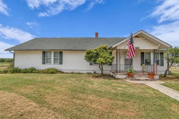 a backyard of a house with table and chairs