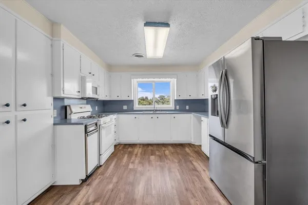 a kitchen with white cabinets and stainless steel appliances