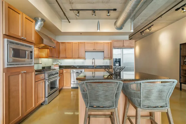 a kitchen with stainless steel appliances granite countertop a sink and cabinets