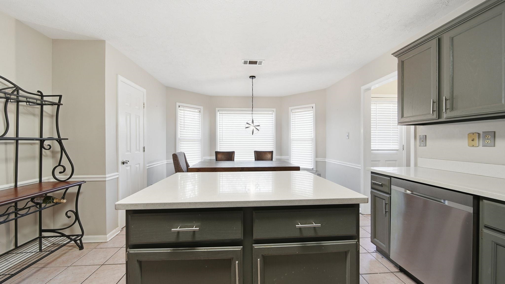 1785 Candle Ridge Drive Cordova, TN 38016 - Photo 15 of 39 Kitchen featuring dishwasher, a center island, plenty of natural light, and light tile patterned floors