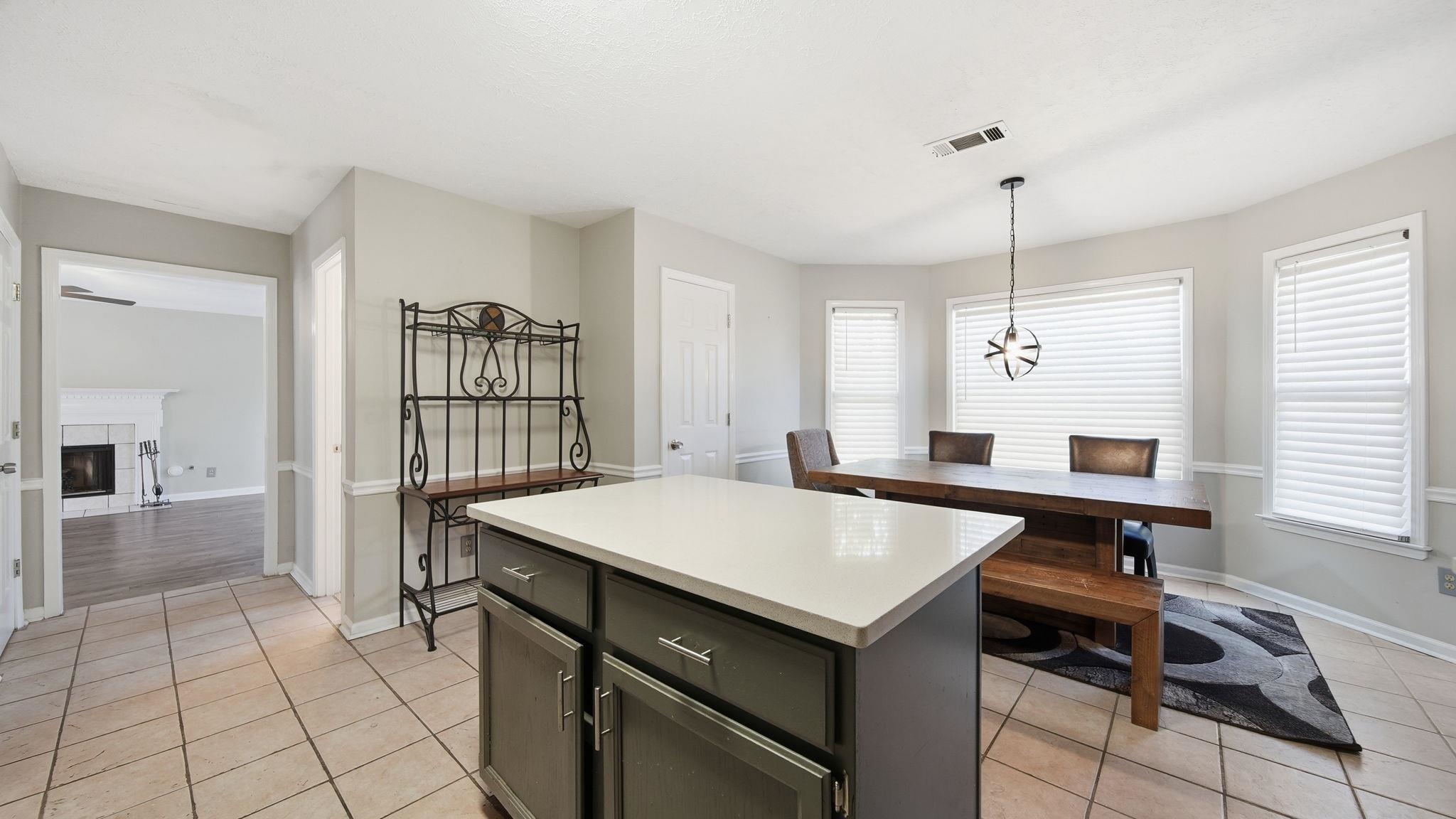 1785 Candle Ridge Drive Cordova, TN 38016 - Photo 20 of 39 Kitchen featuring a center island, light countertops, a fireplace, and healthy amount of natural light