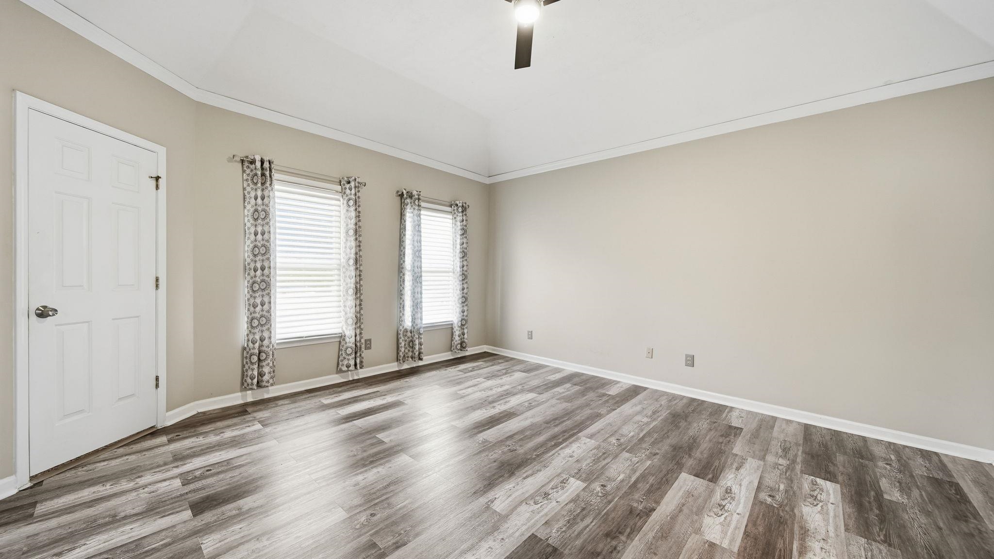 1785 Candle Ridge Drive Cordova, TN 38016 - Photo 23 of 39 Unfurnished room featuring crown molding, lofted ceiling, wood finished floors, and ceiling fan