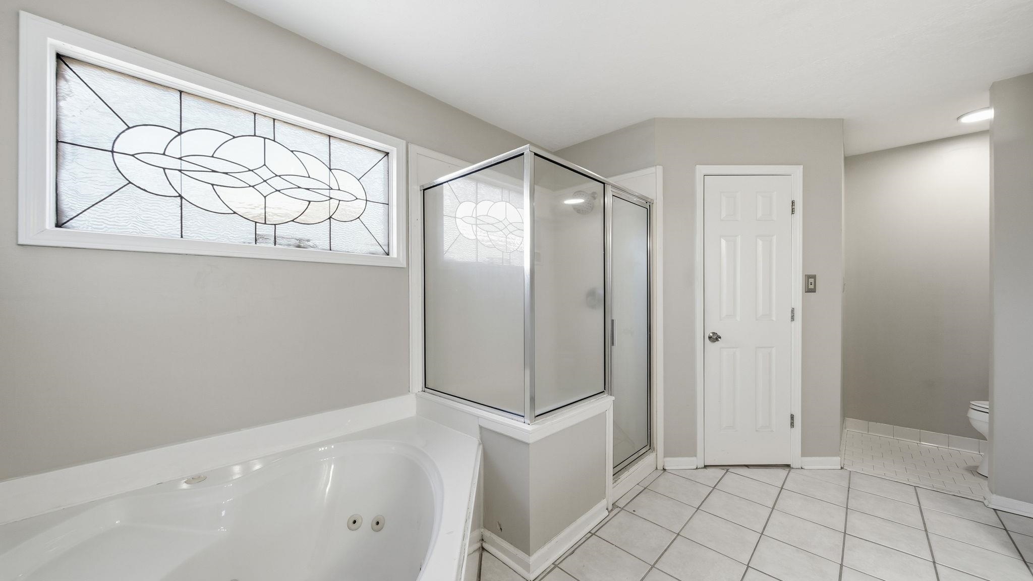 1785 Candle Ridge Drive Cordova, TN 38016 - Photo 28 of 39 Full bathroom featuring a jetted tub, a shower stall, and light tile patterned floors