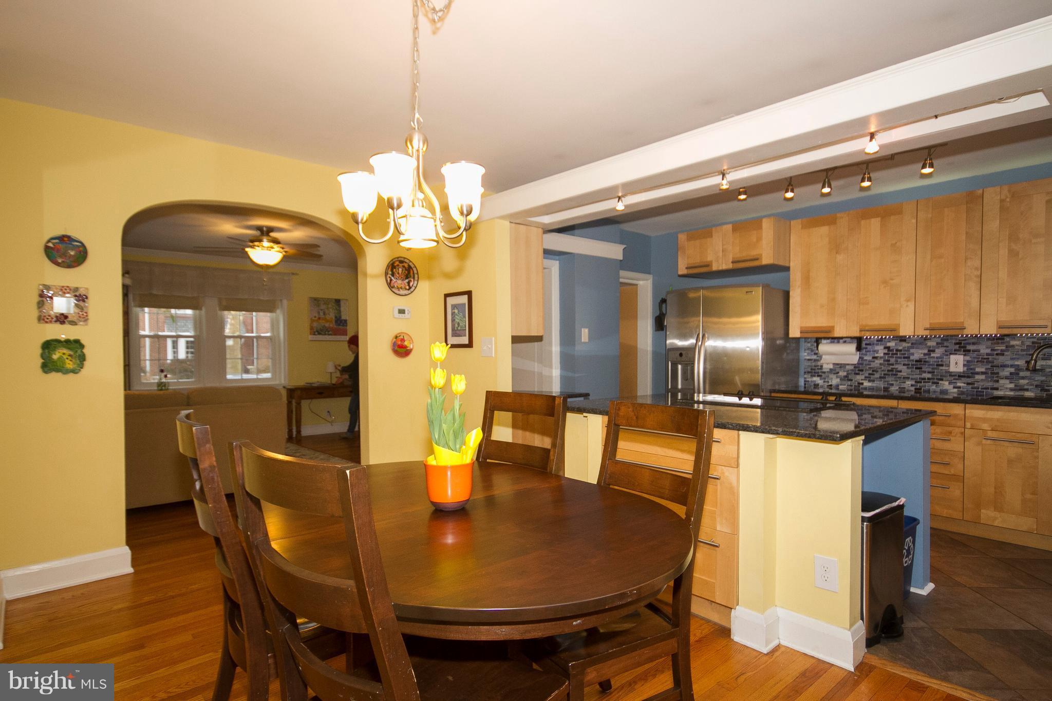 326 Murdock Road Baltimore, MD 21212 - Photo 10 of 29 a dining room with wooden floor a chandelier a wooden table and chairs