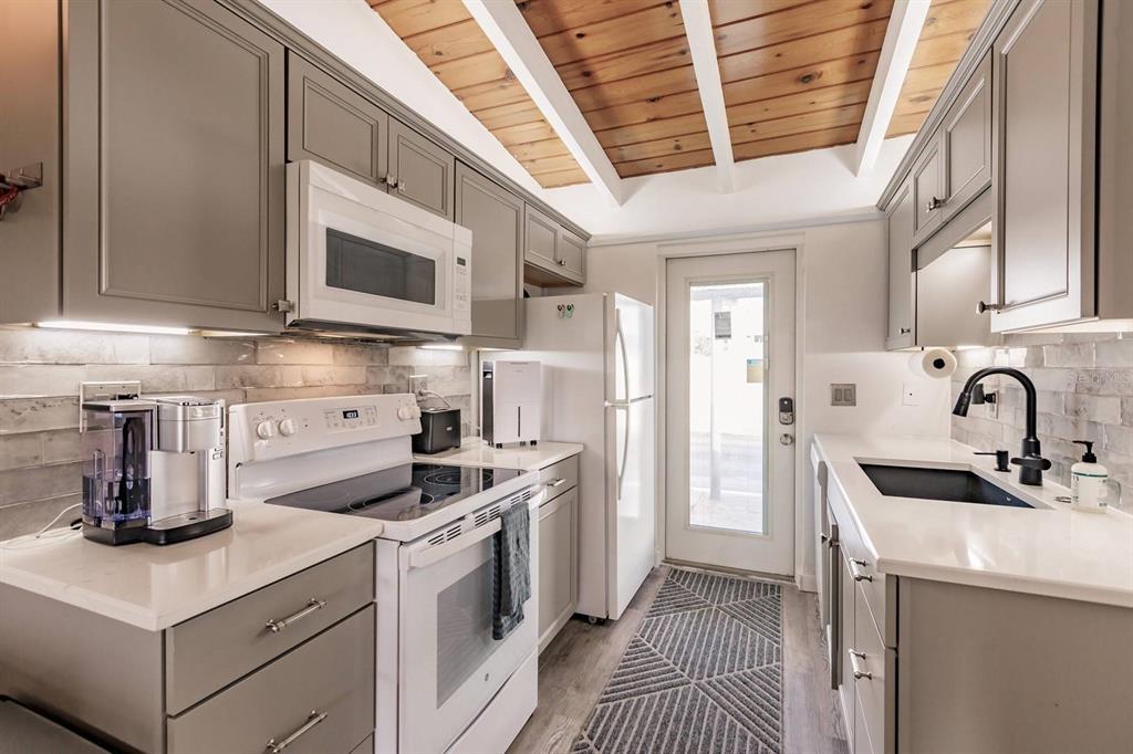 6006 Midnight Pass Road, Unit 2 Sarasota, FL 34242 - Photo 6 of 15 a kitchen with stainless steel appliances granite countertop a sink and a stove