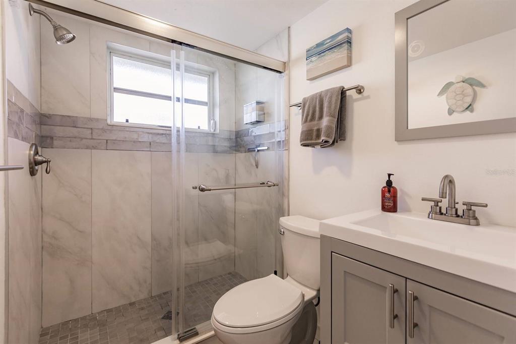 6006 Midnight Pass Road, Unit 2 Sarasota, FL 34242 - Photo 8 of 15 a bathroom with a sink a toilet and shower
