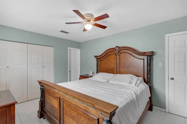 a bedroom with a bed and a ceiling fan