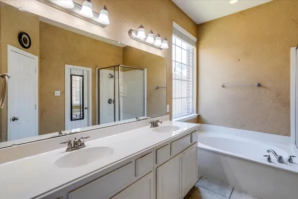 a bathroom with a tub a sink and mirror