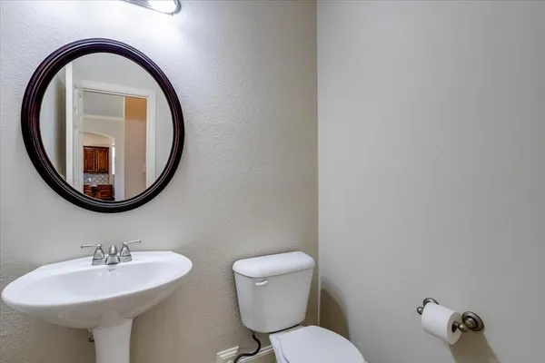 a bathroom with a toilet a sink and a mirror