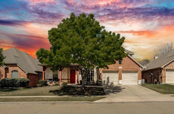 a front view of a house with a tree