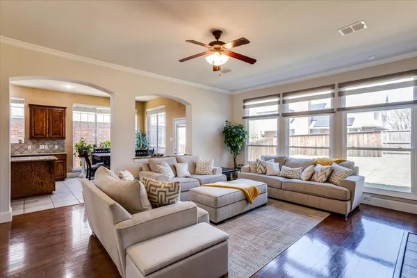a living room with furniture ceiling fan and a large window
