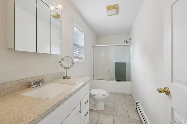 a bathroom with a granite countertop sink a toilet and mirror