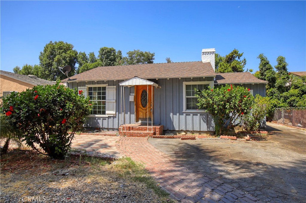 a view of a house with a small yard and potted plants