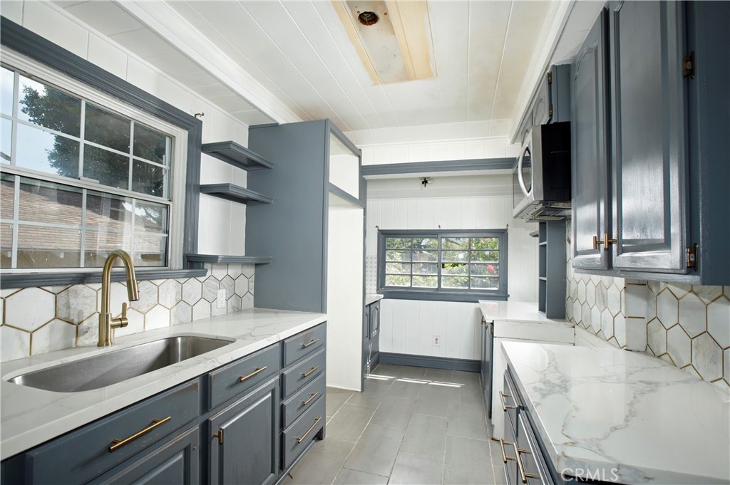 7339 Baird Avenue Reseda, CA 91335 - Photo 7 of 22 a large white kitchen with a granite countertop sink