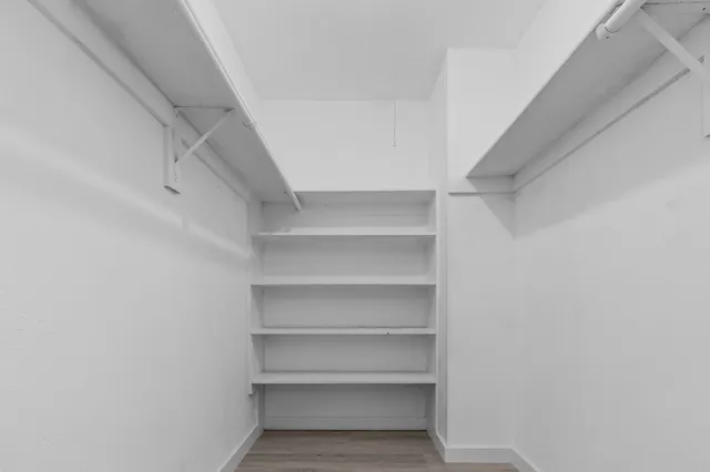 a view of walk in closet with empty racks