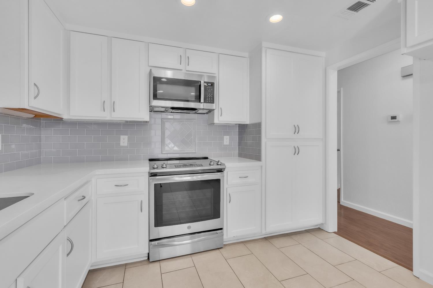 136 Rambling Drive Folsom, CA 95630 - Photo 12 of 31 a kitchen with white cabinets stainless steel appliances and sink