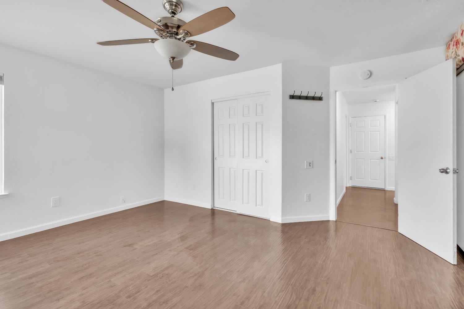 136 Rambling Drive Folsom, CA 95630 - Photo 21 of 31 an empty room with wooden floor ceiling fan and windows