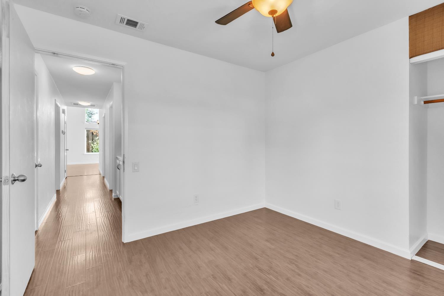 136 Rambling Drive Folsom, CA 95630 - Photo 24 of 31 a view of a hallway with wooden floor and a chandelier fan