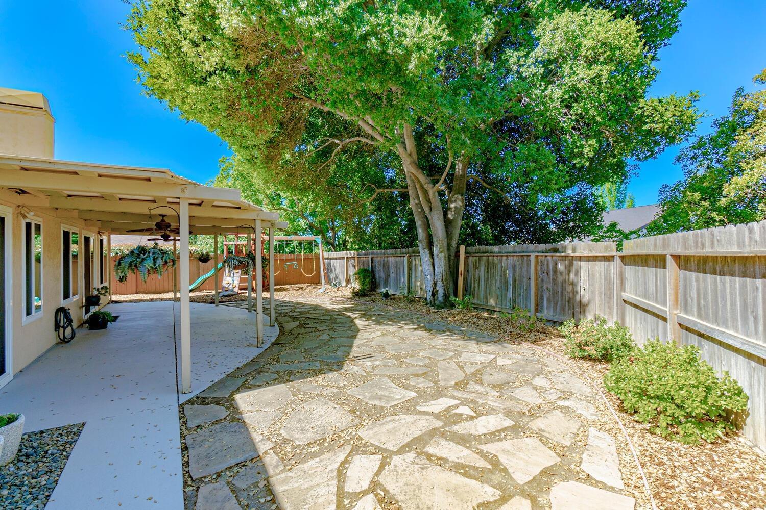 136 Rambling Drive Folsom, CA 95630 - Photo 25 of 31 a view of a patio with table and chairs under an umbrella