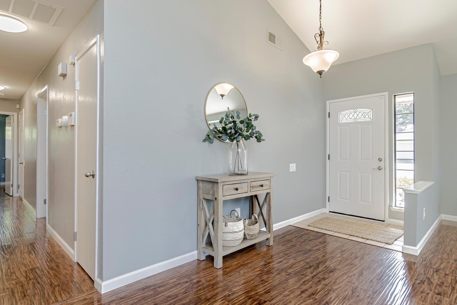 136 Rambling Drive Folsom, CA 95630 - Photo 8 of 31 a view of a hallway with wooden floor and a chandelier