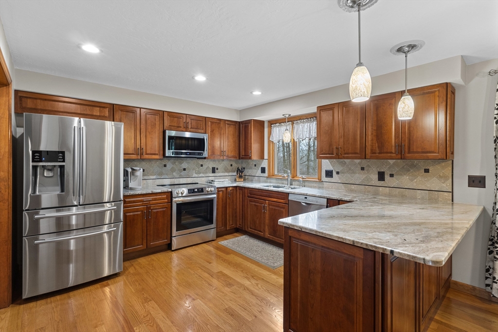 16 Flint Pond Road Worcester, MA 01604 - Photo 12 of 42 a kitchen with stainless steel appliances granite countertop a sink a stove a refrigerator cabinets and a kitchen island