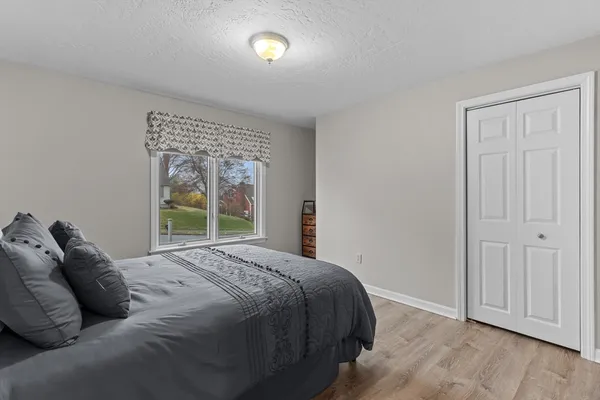 a bedroom with a bed and wooden floor